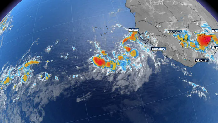 Satellite view of a tropical disturbance over the Atlantic with forecast tracks