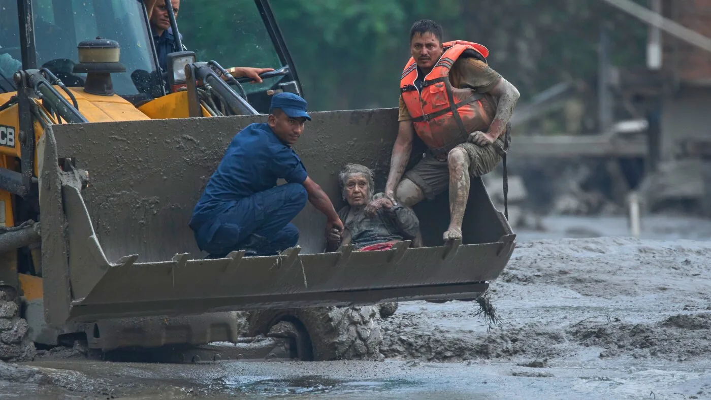 Mud-covered buildings and damaged roads after floods in a mountain border area