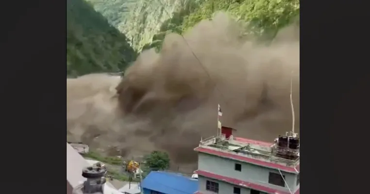 Floodwater rushes through a mountain valley, damaging roads, bridges and buildings in Nepal