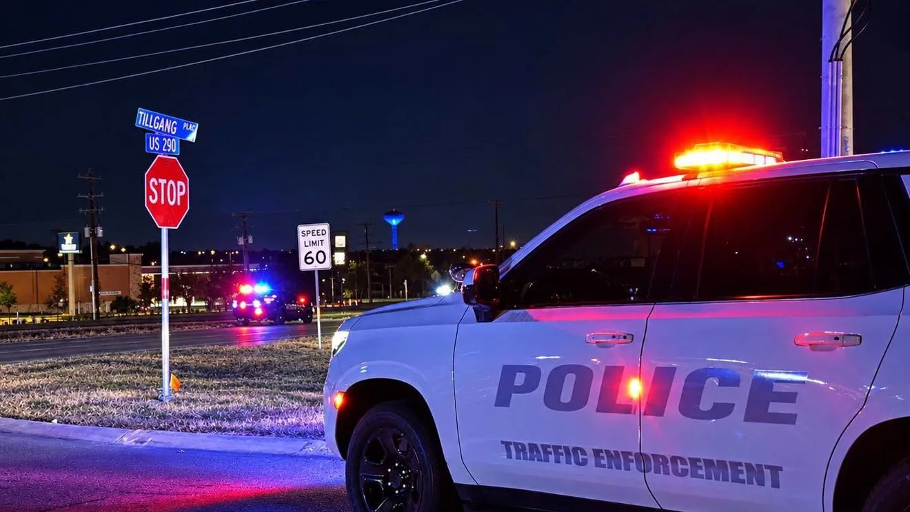 Police patrol vehicle and investigators at a closed stretch of US 290 after a fatal crash