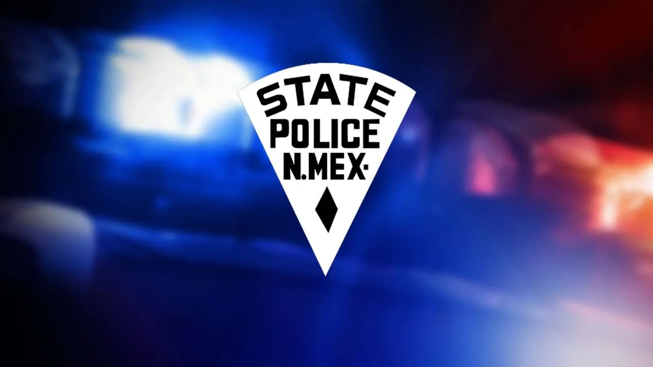 Police investigate a fatal crash scene on a wet highway near Rio Rancho